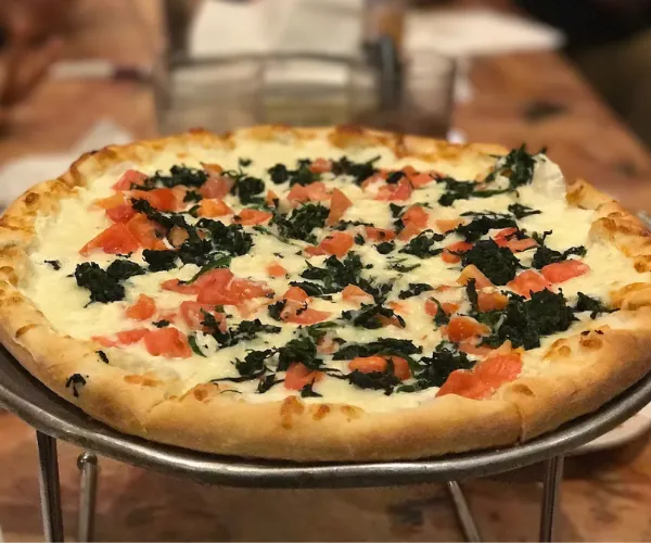 Cheese pizza with spinach and tomatoes