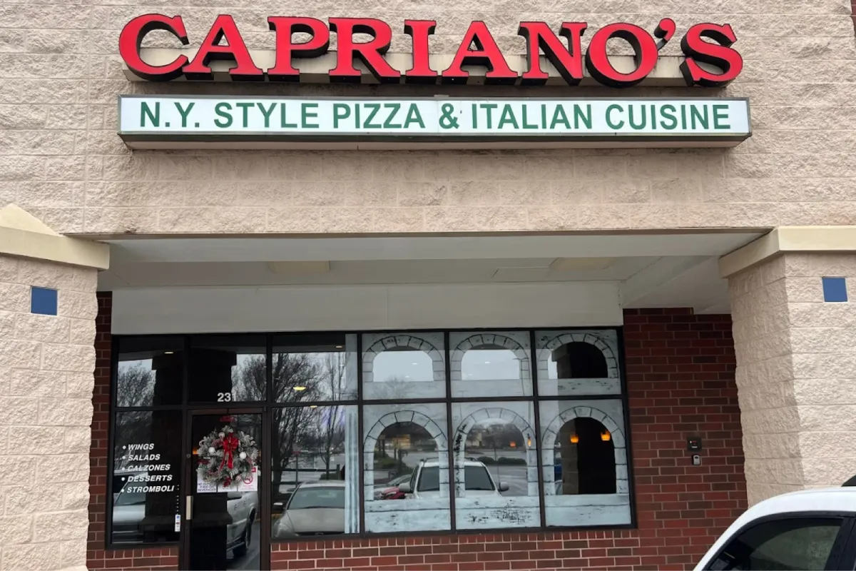 Exterior of "Capriano's" Italian restaurant with a sign showing "NY Style Pizza & Italian Cuisine."