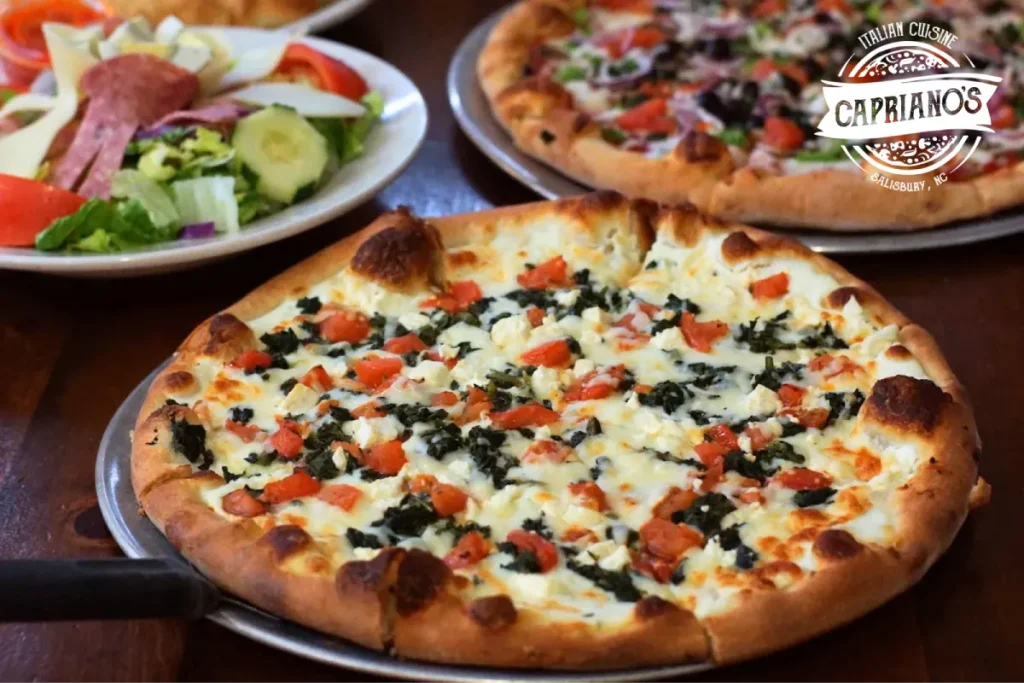 Italian catering pizza with salad and another pizza in background