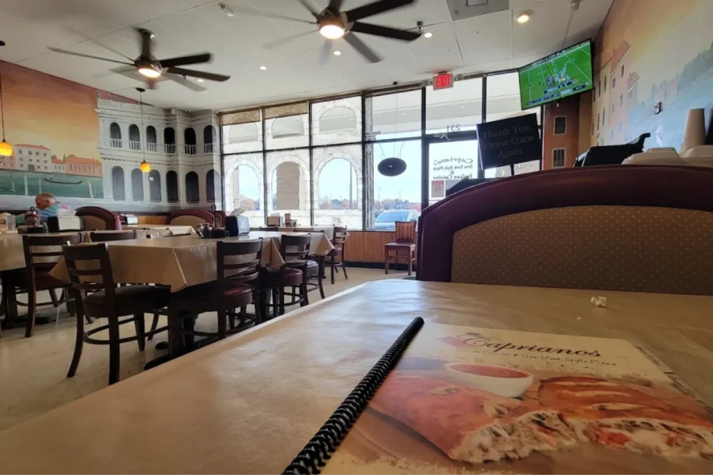 Italian restaurant dining room with tables and menu on table.